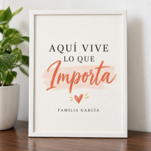Lámina con frase personalizada "Aquí vive lo que importa" en lettering terracota con apellido familiar y marco blanco